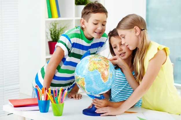 smiling-students-looking-globe_1098-1192